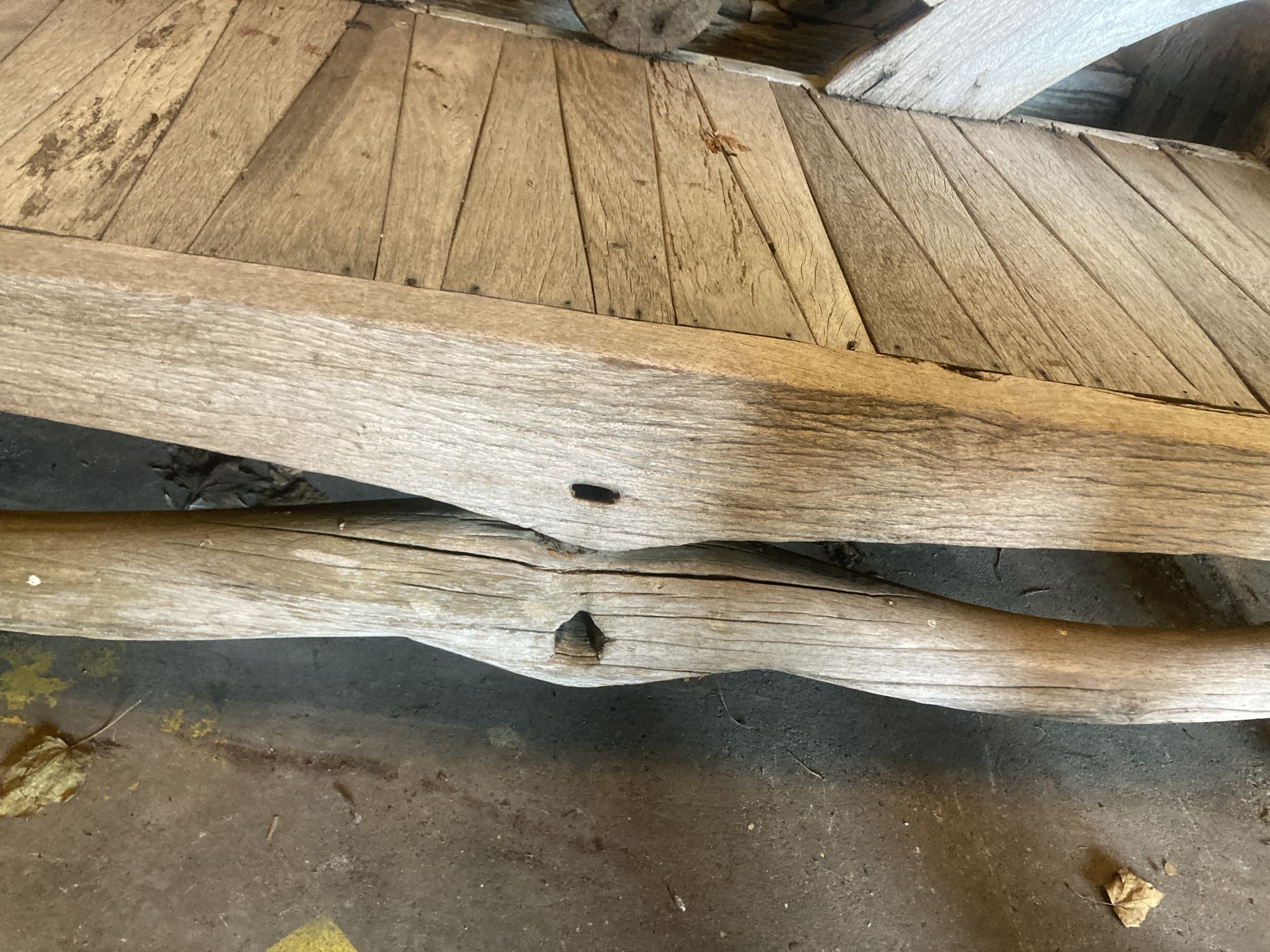 A pair of weathered hardwood cartwheel and hub garden benches, width 184cm depth 75cm height 105cm